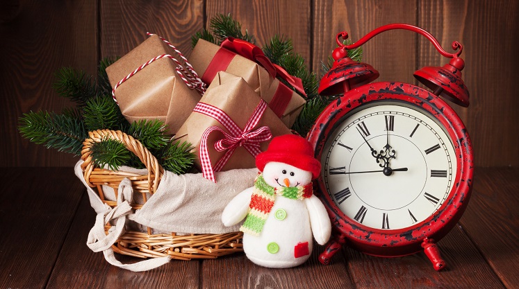 Christmas gift boxes and fir tree branch in basket with alarm cl